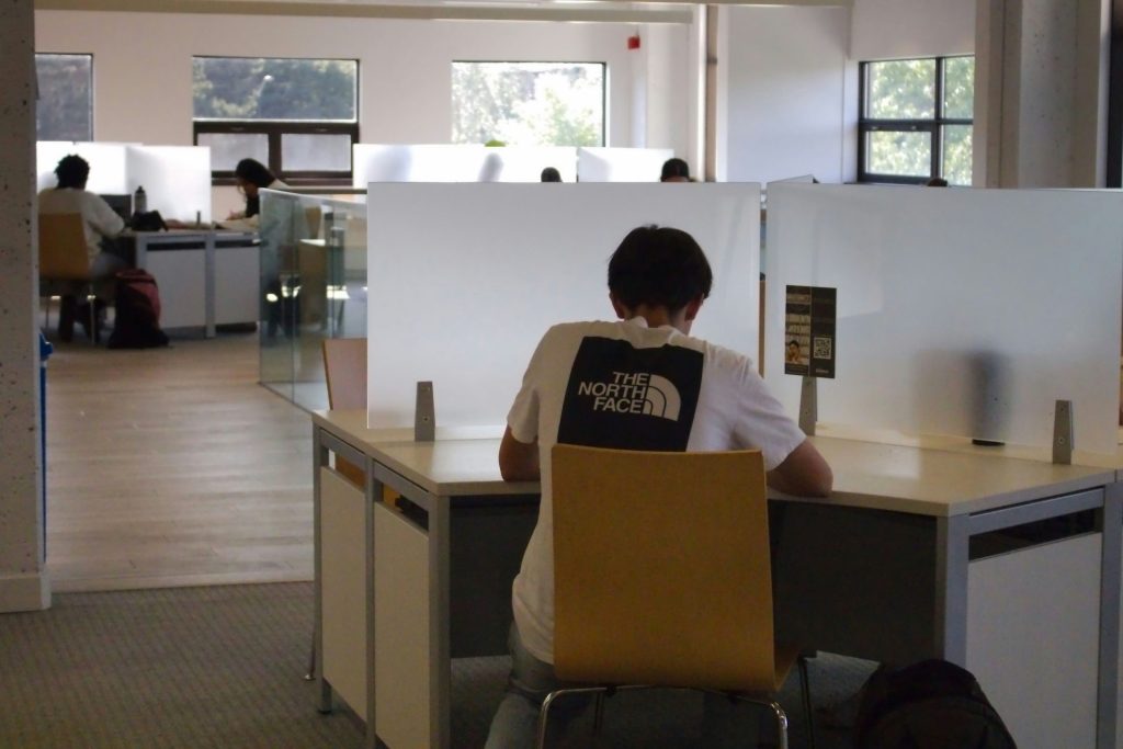 Eine Person sitzt an einem Schreibtisch mit einem Laptop